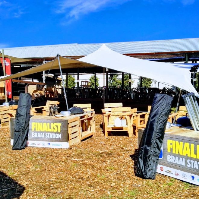 Stretch tent setup at Braai Station, showcasing wooden seating