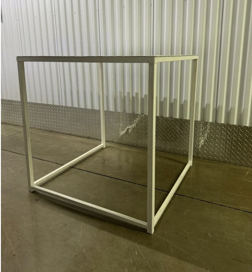 Empty white table frame on a concrete floor