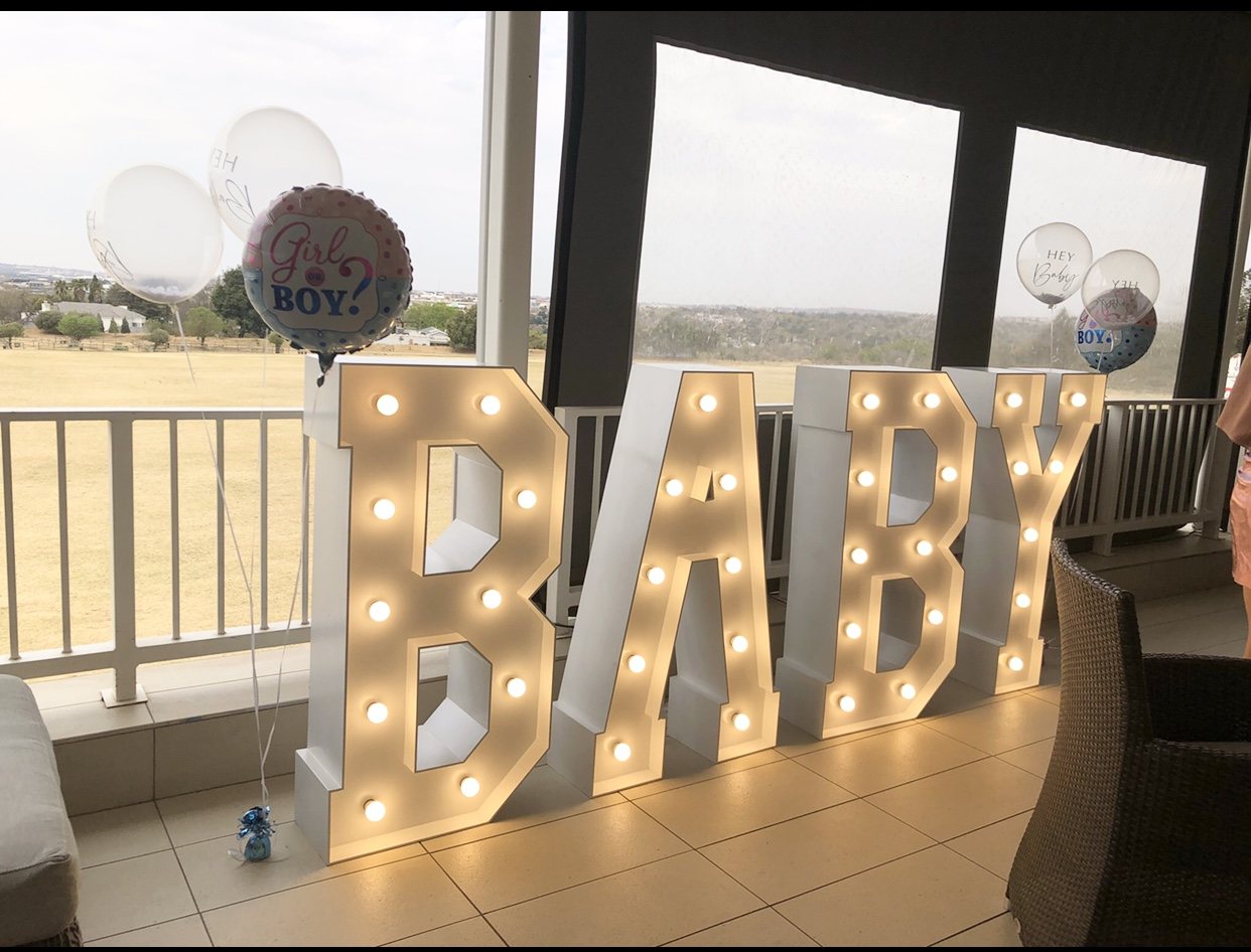 Large illuminated letters spelling 'BABY' with balloons