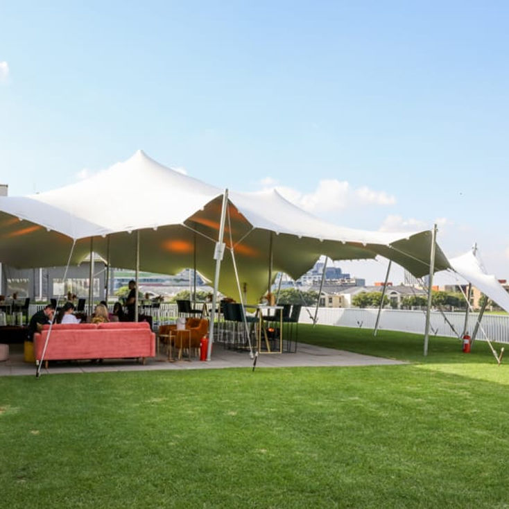 Stretch tent set up on grass for an outdoor event