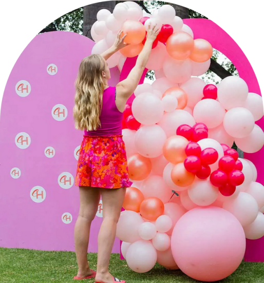 A person arranging a colorful balloon installation