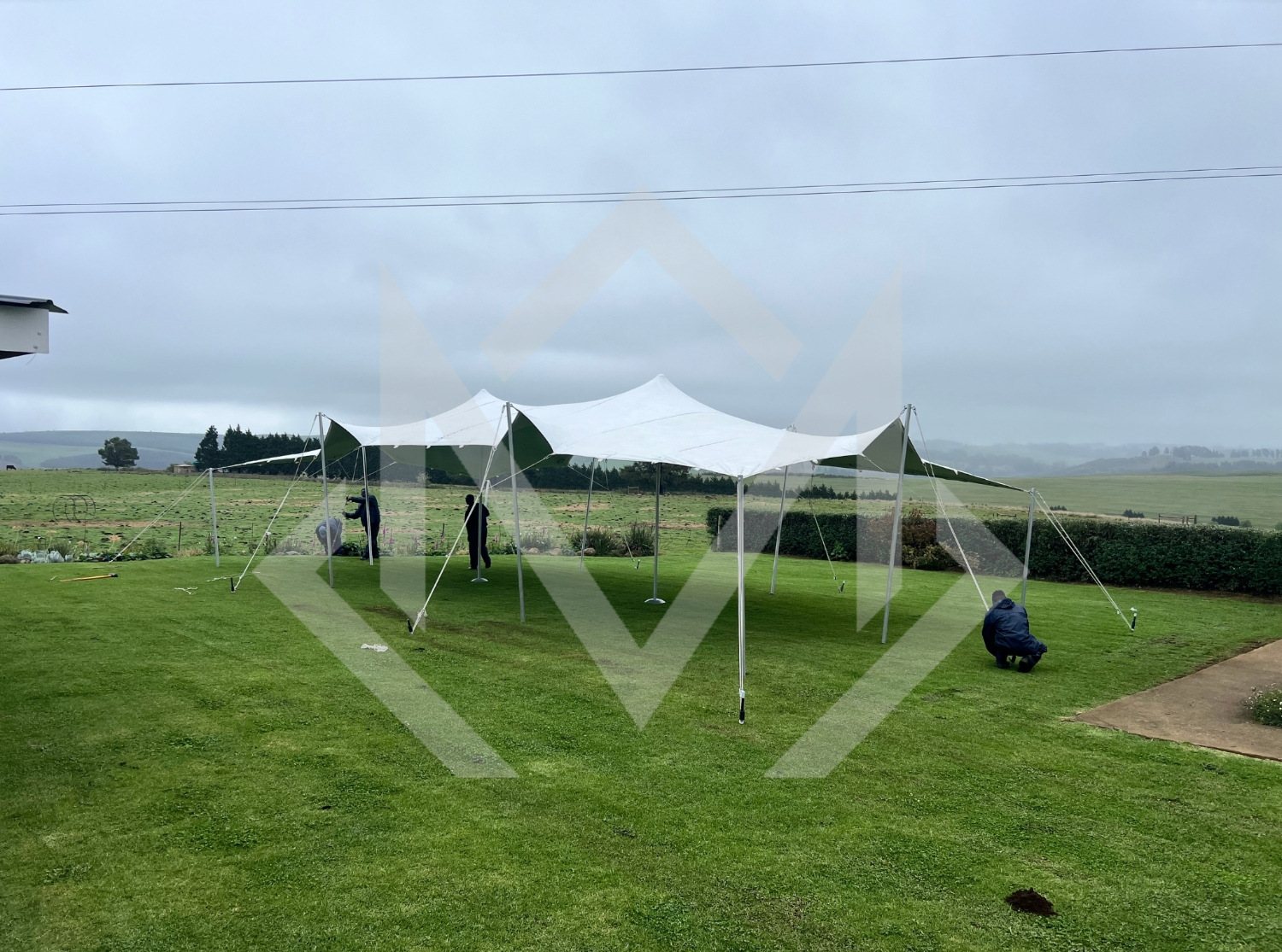 Team setting up a stretch tent on grass