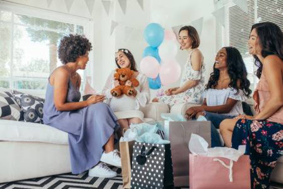 Group of women celebrating a baby shower in a bright room.