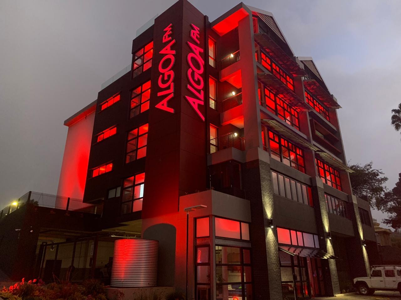 Exterior view of a building with red lighting, showcasing its architecture.