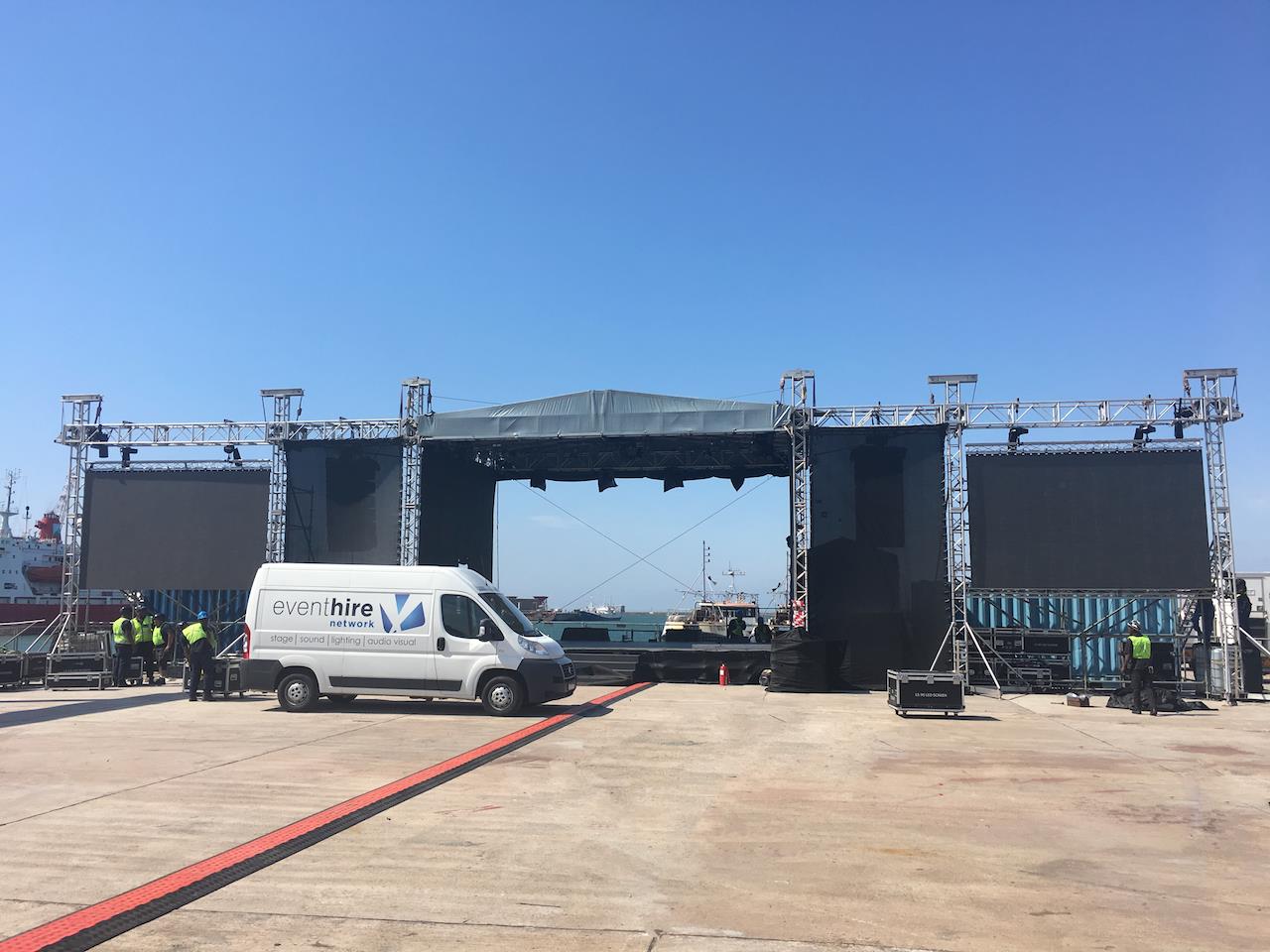 Large outdoor stage with screens and van on-site