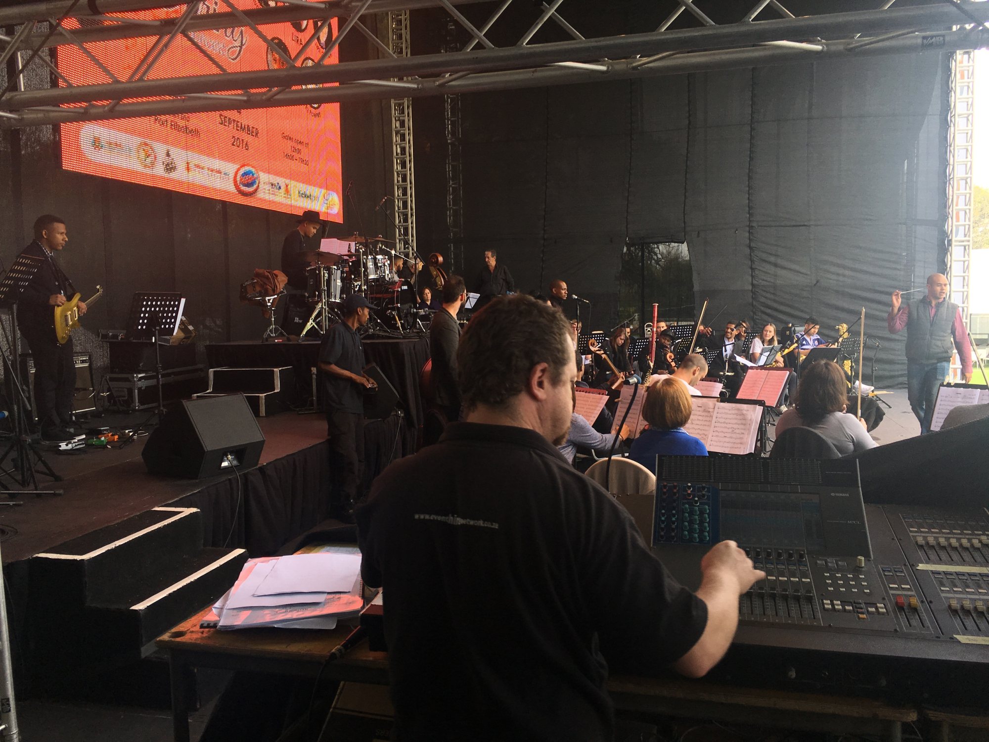 Technician operating sound equipment at a live event stage.