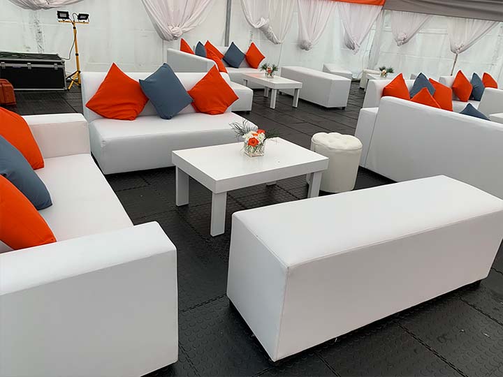White couches with orange and blue cushions in a lounge area