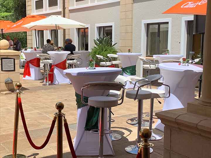 Outdoor cocktail tables with white cloths and colored sashes
