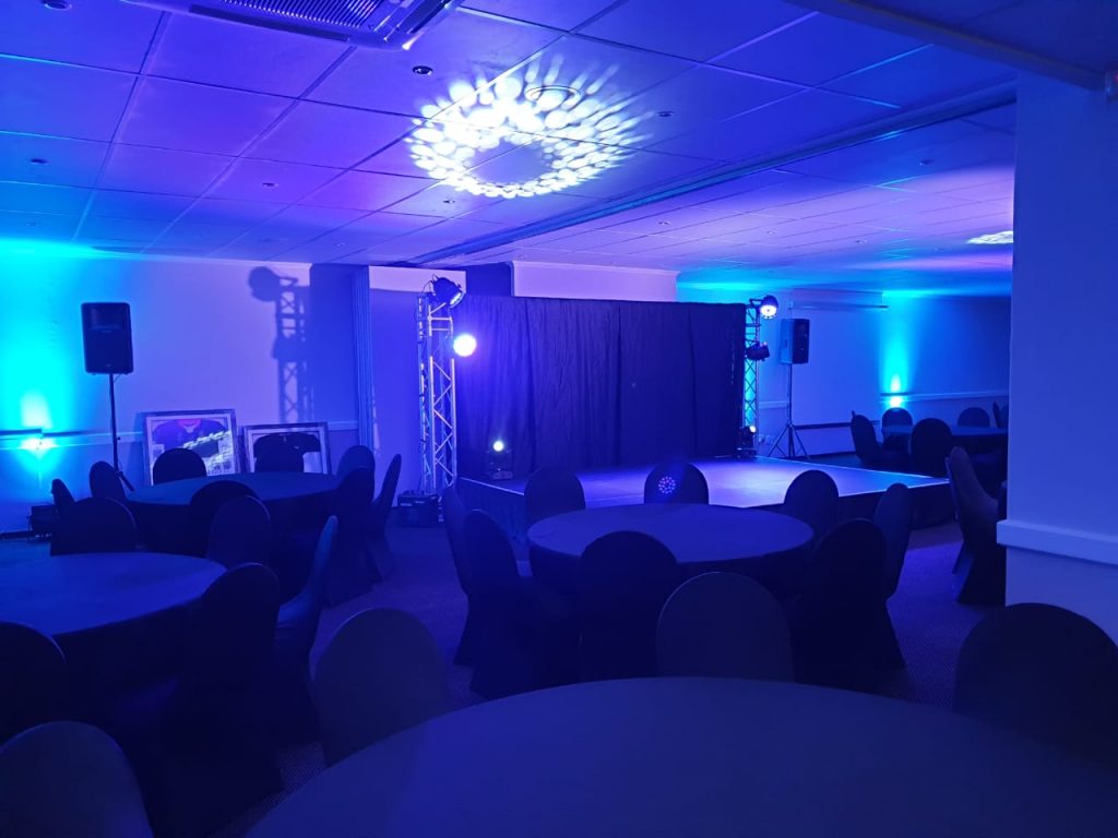 Corporate event space with tables, chairs, and lighting