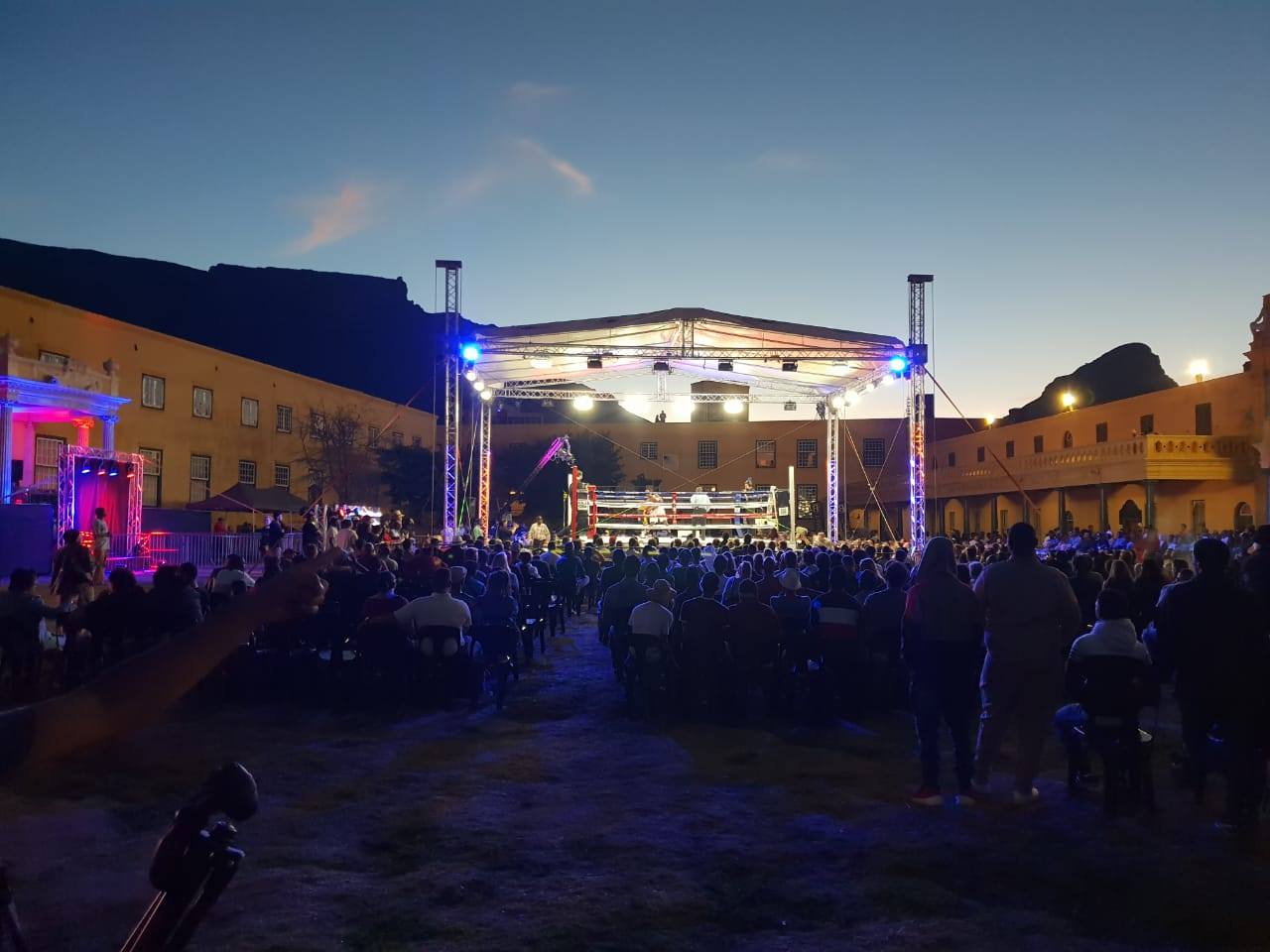 Outdoor event lighting setup with a boxing ring and audience