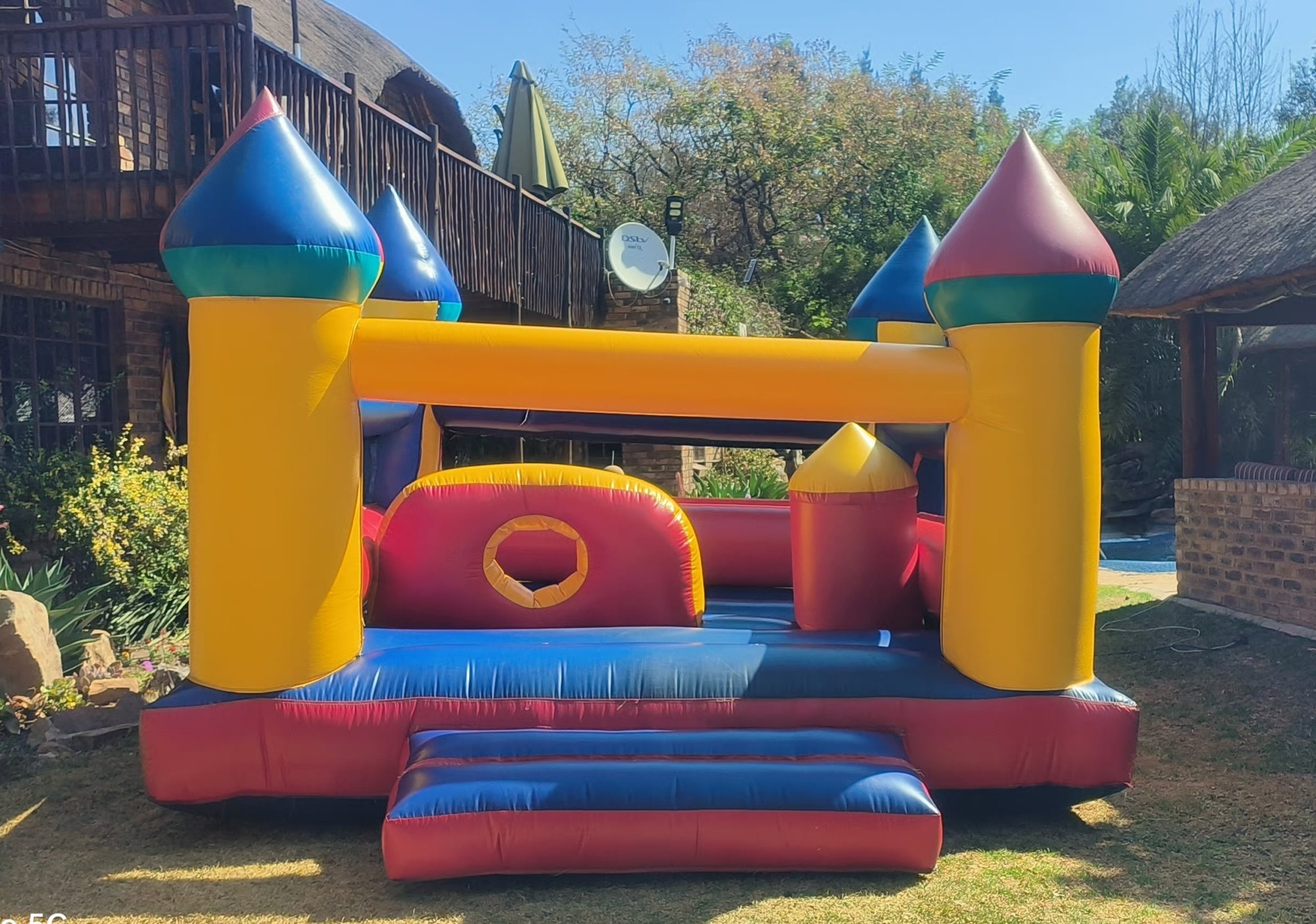 Vibrant yellow and blue jumping castle on green grass