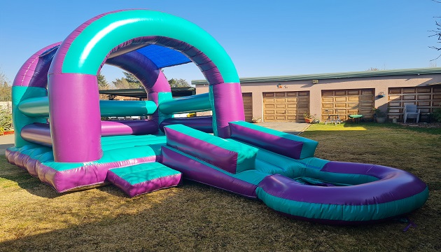 Vibrant jumping castle with slide set up in a yard