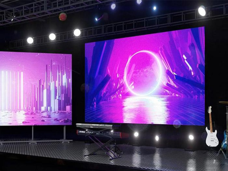 Two vibrant LED screens displaying colorful digital graphics on stage