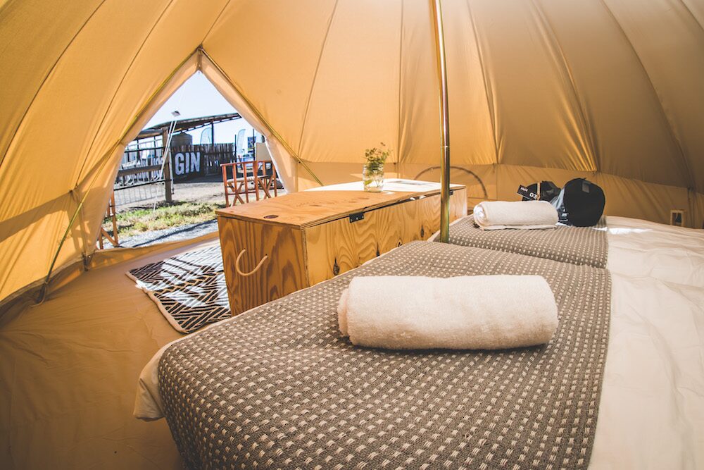 Interior view of a glamping tent with beds and furnishings