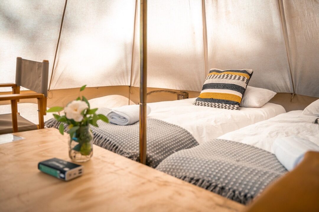 Interior of a glamping tent with beds and a table