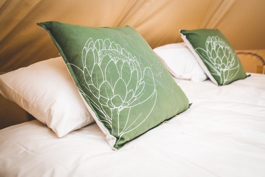 Glamping tent interior with cushions and bedding