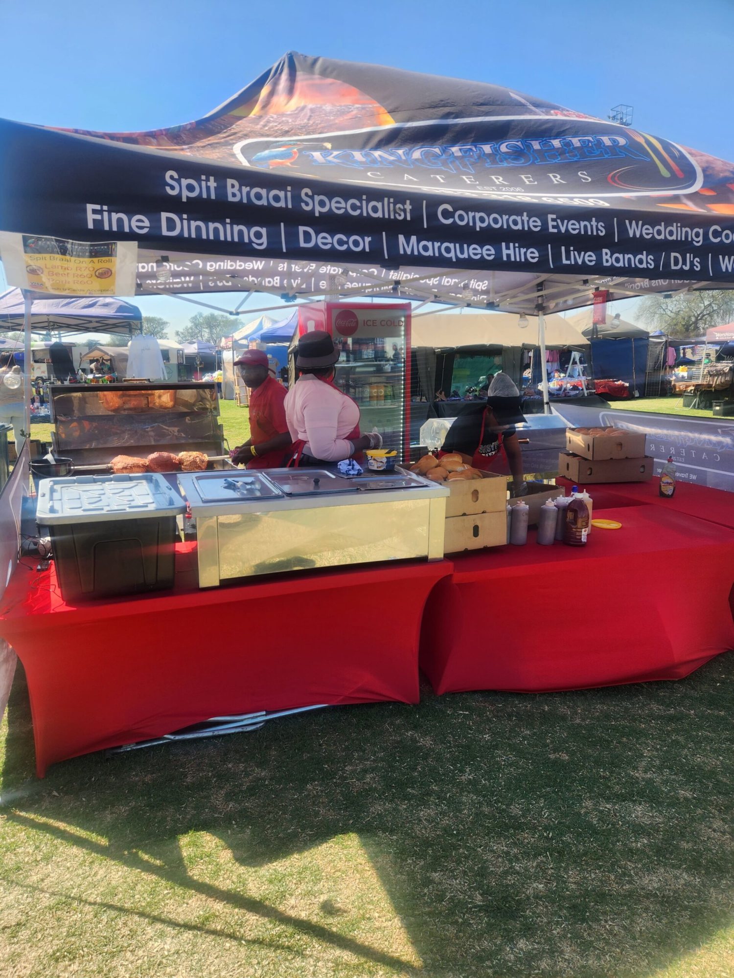 Catering setup with spit braai and staff in a tent