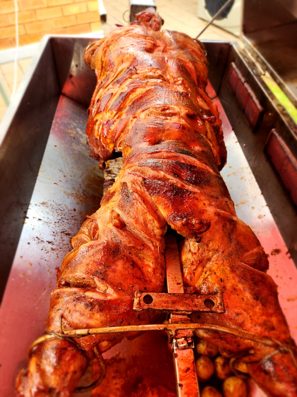 Whole lamb on a spit braai, seasoned and ready for serving.