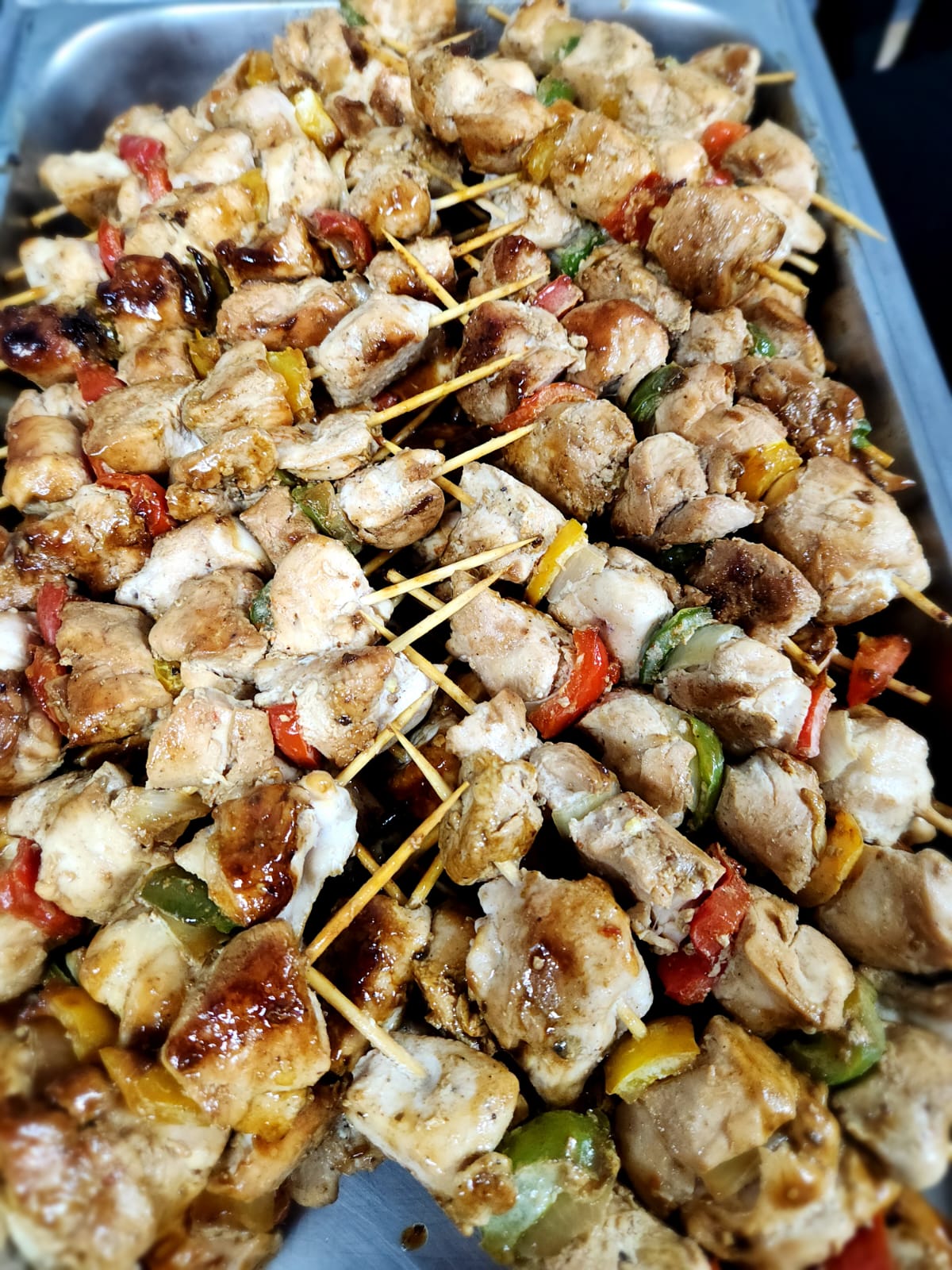 Trays of marinated chicken skewers with vegetables