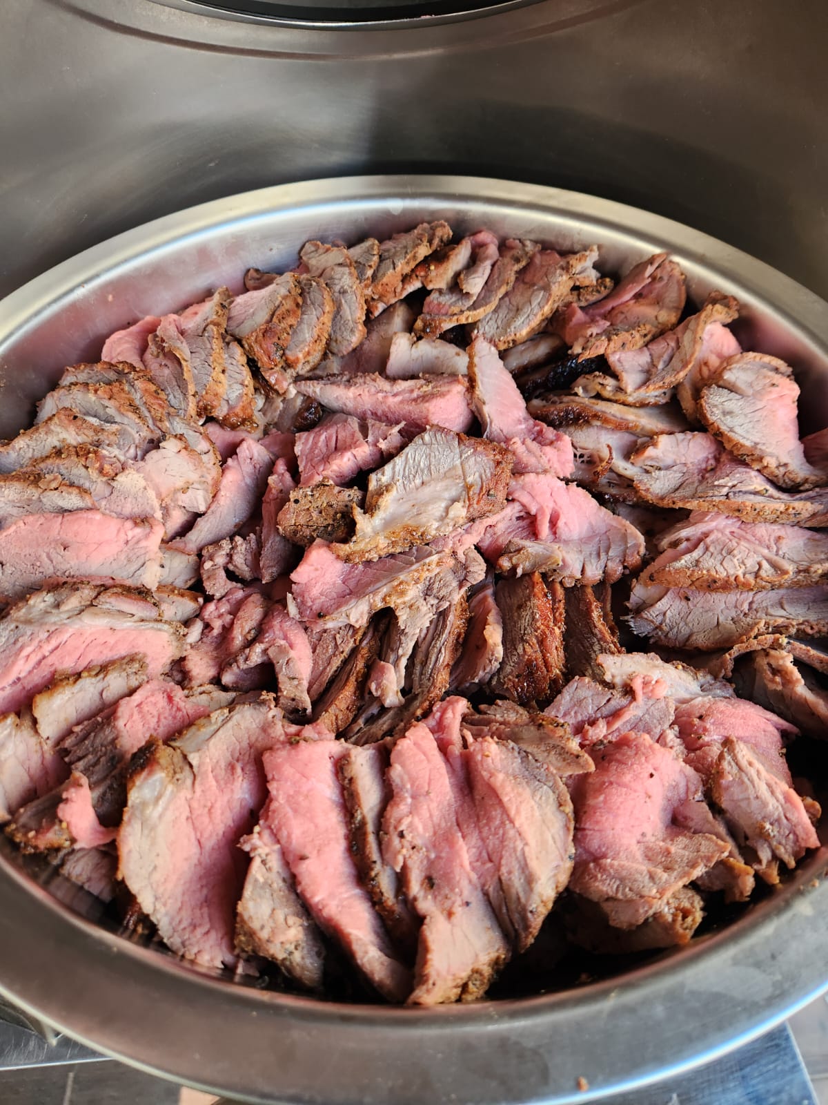 A platter of sliced roast beef arranged in a circular pattern.