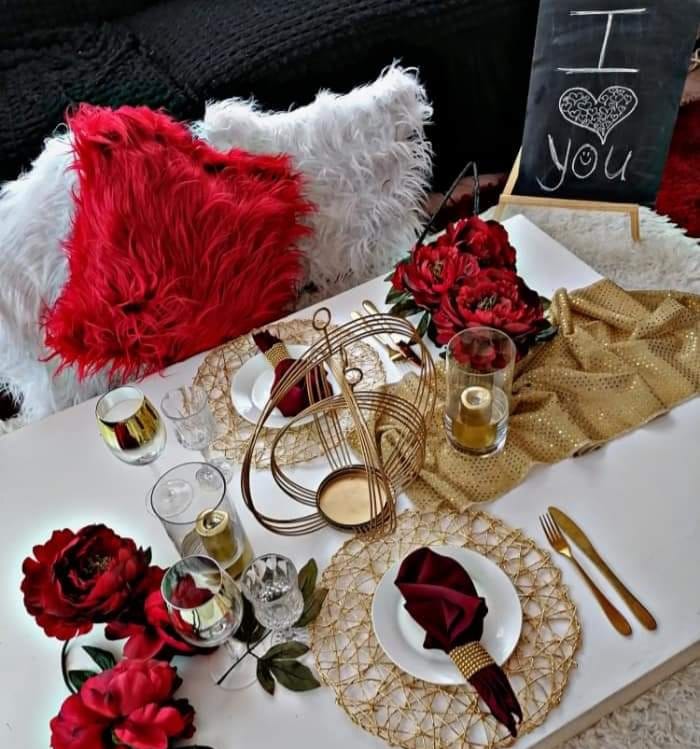 Stylish picnic table set with red flowers and gold accents