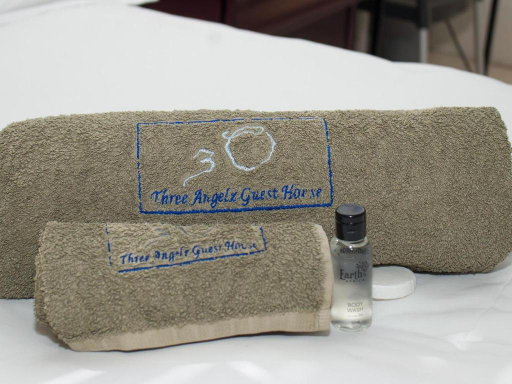 Embroidered guest towels and body wash on a bed