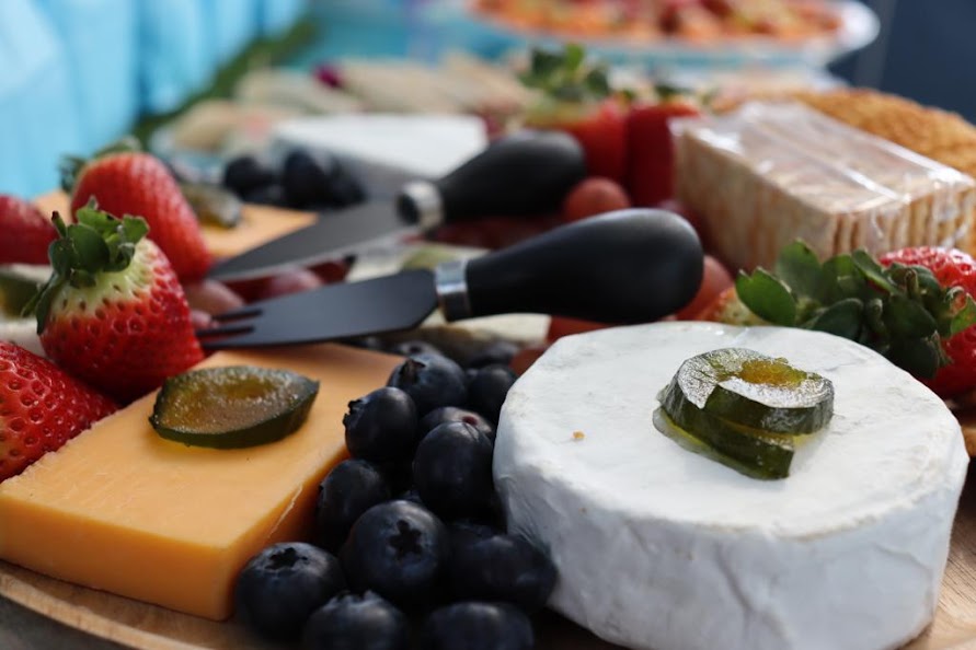 Cheese platter with strawberries, blueberries, and cheese varieties
