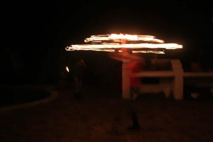 Fire poi dancer performing with flames at night