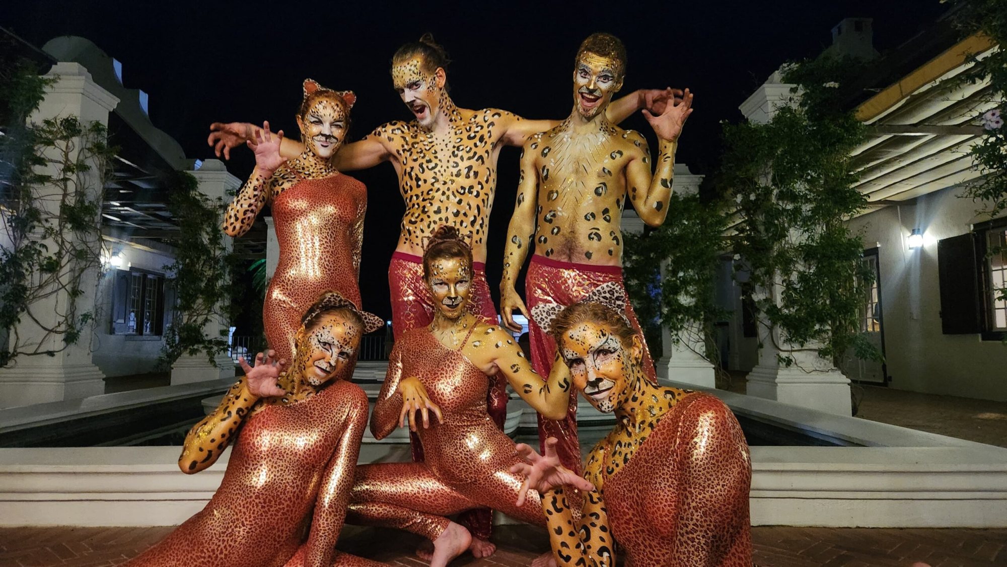 Six performers in leopard-themed costumes with body paint.