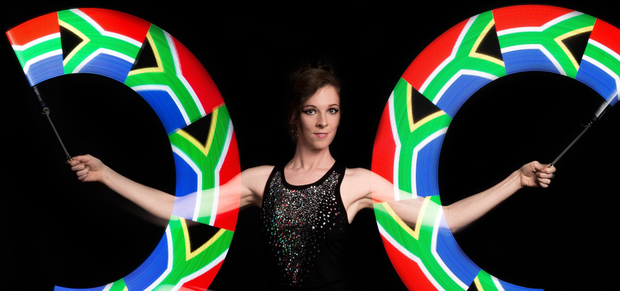 LED performer with South African flag-themed poi