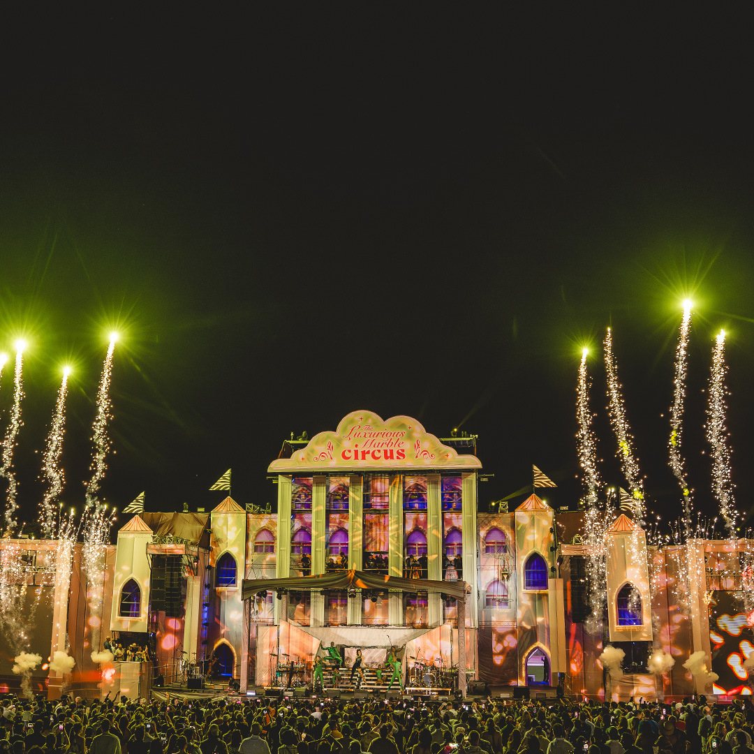 Stage performance with fireworks and large crowd