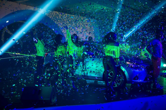 Dancers celebrate with confetti falling in a festive scene.
