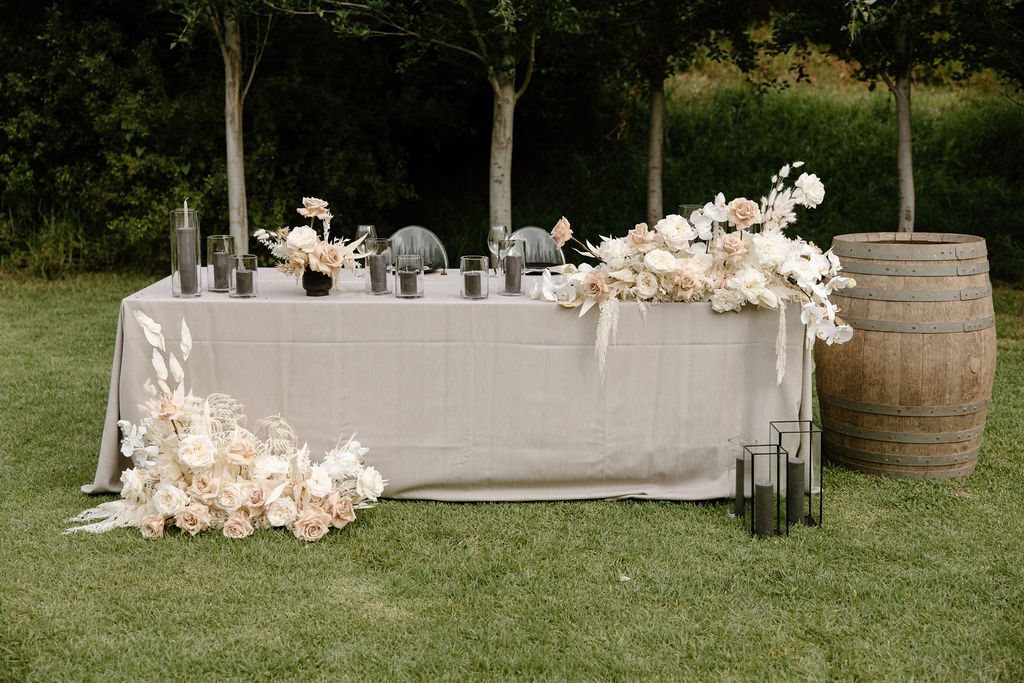 Table decorated with candles and florals in a garden setting