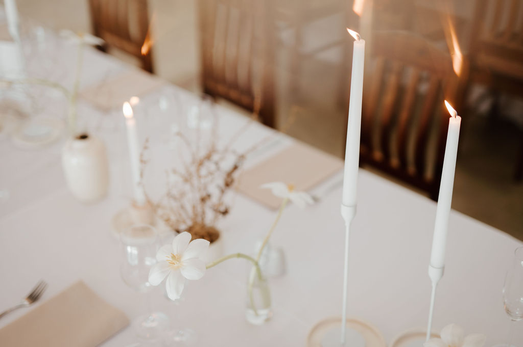 Table set with white candles and floral accents