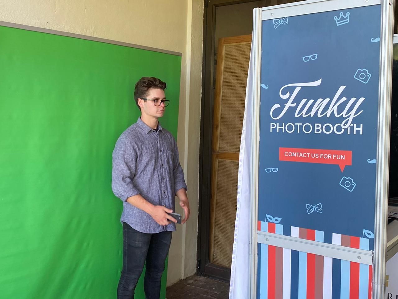 Green screen photo booth setup with contact info