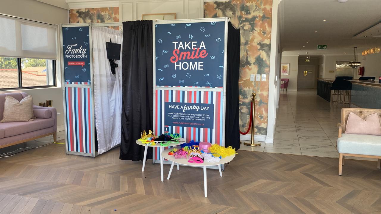 Vibrant photo booth setup with colorful props and backdrop.