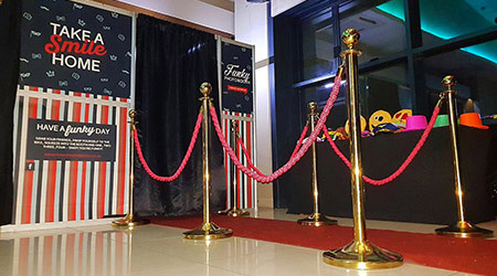Elegant photo booth setup with red carpet and colorful props.