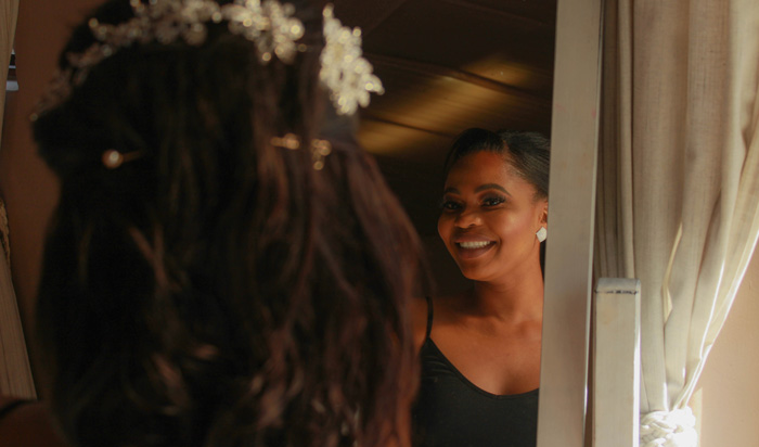A smiling guest preparing in front of a mirror