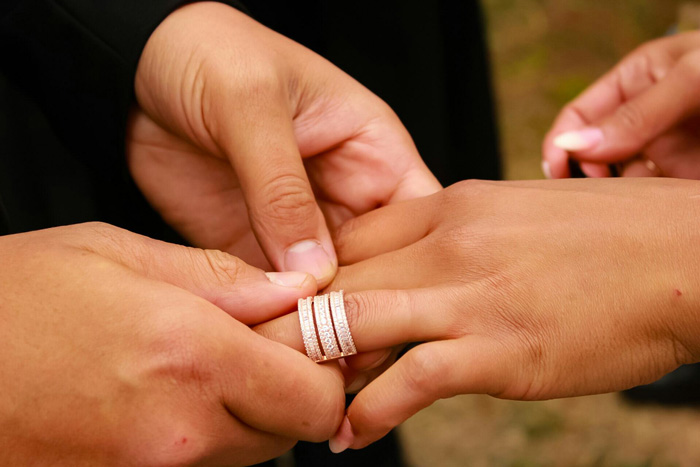 Two hands exchanging a ring during a wedding ceremony
