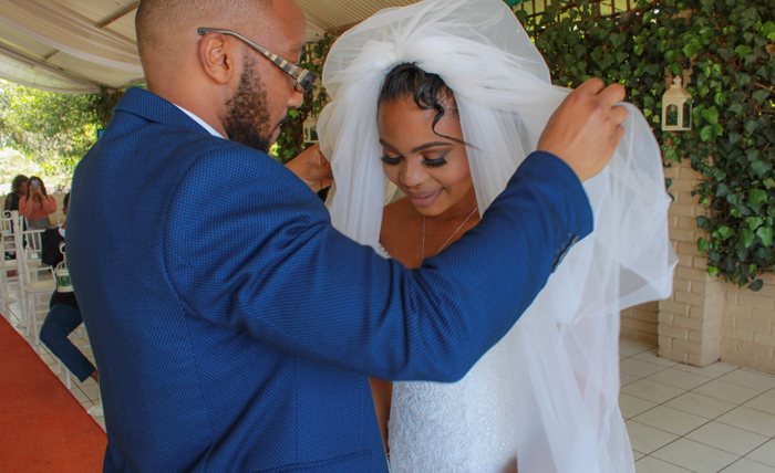 Bride and groom adjusting veil during preparation