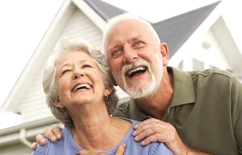 A happy elderly couple smiling outdoors