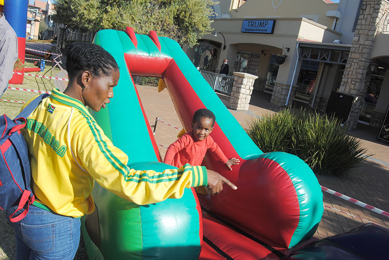 A child on a red and green inflatable slide.