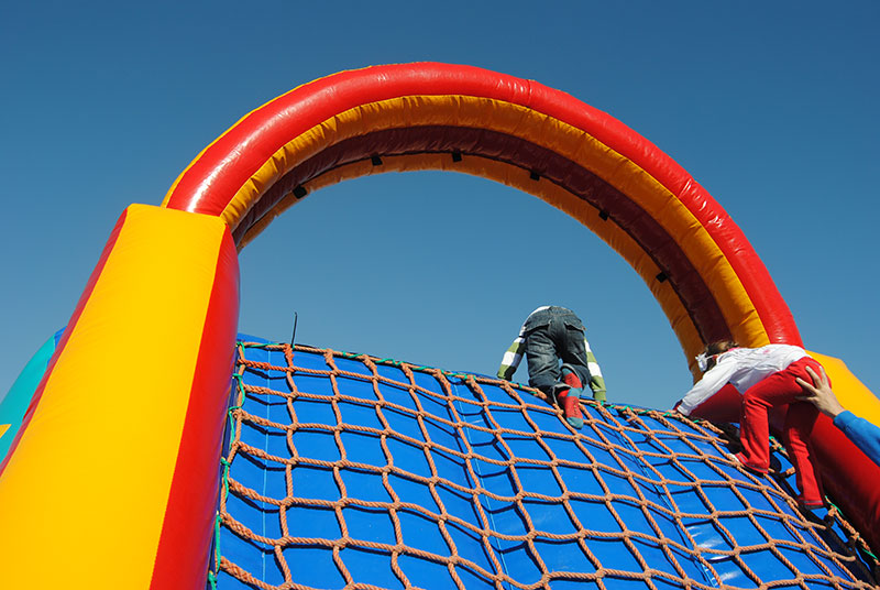Children climbing a colorful inflatable climbing wall.