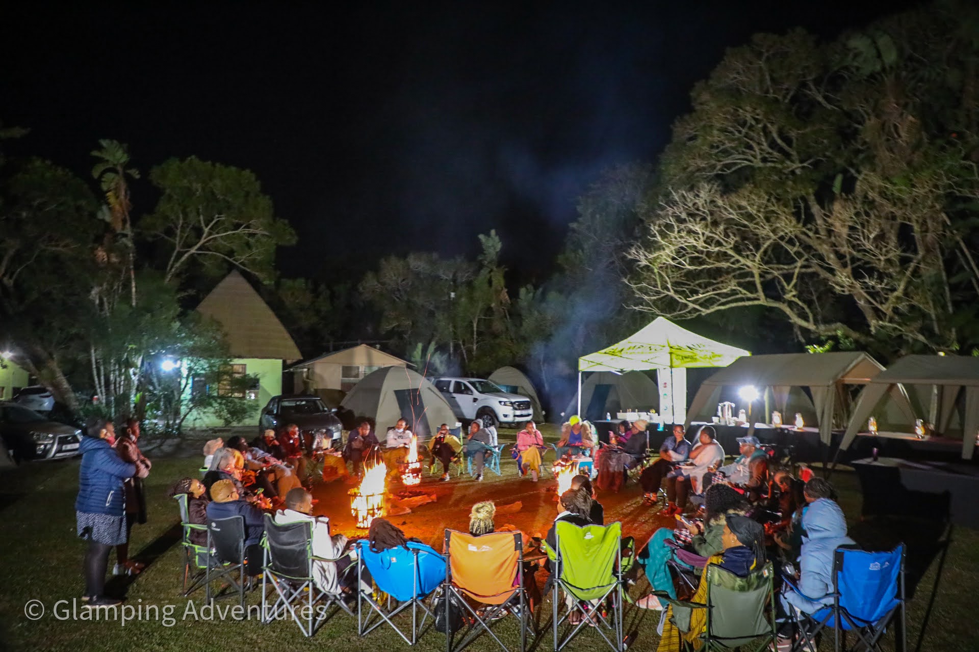Group of people around a campfire at glamping site