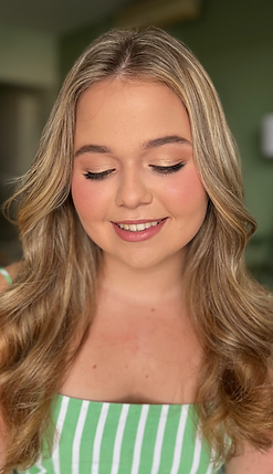 Bridal hairstyle and makeup with loose waves and natural tones.