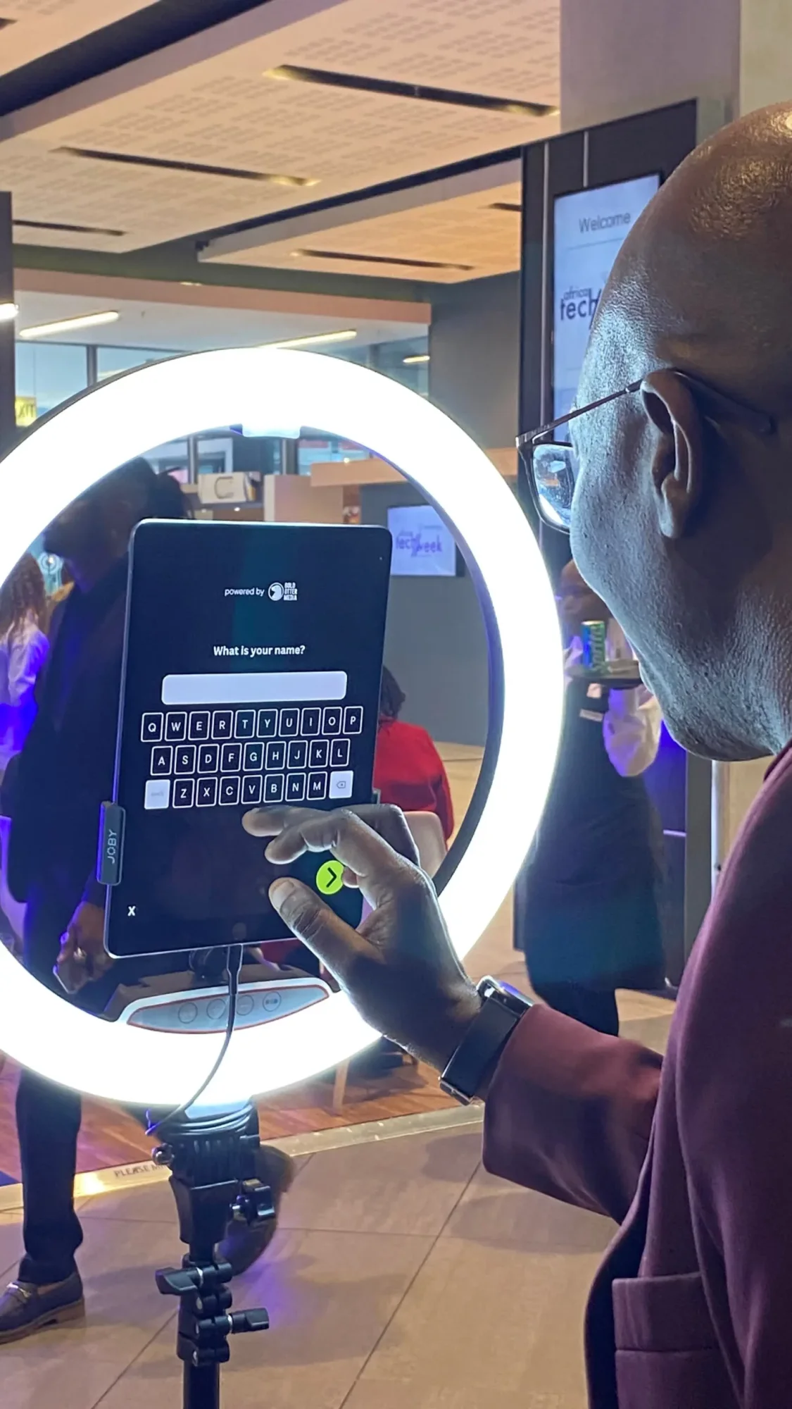 Man using AI photo booth touch screen.
