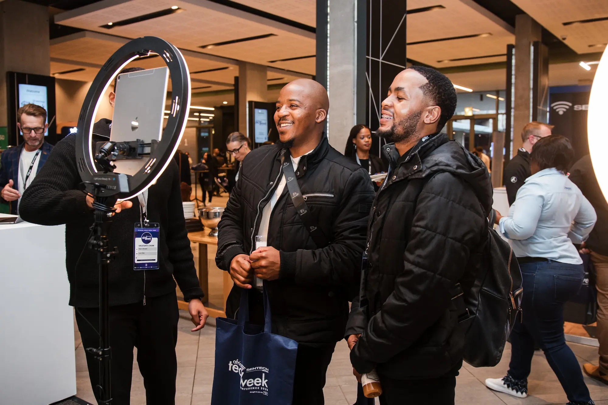 Two guests using an AI photo booth with a ring light.