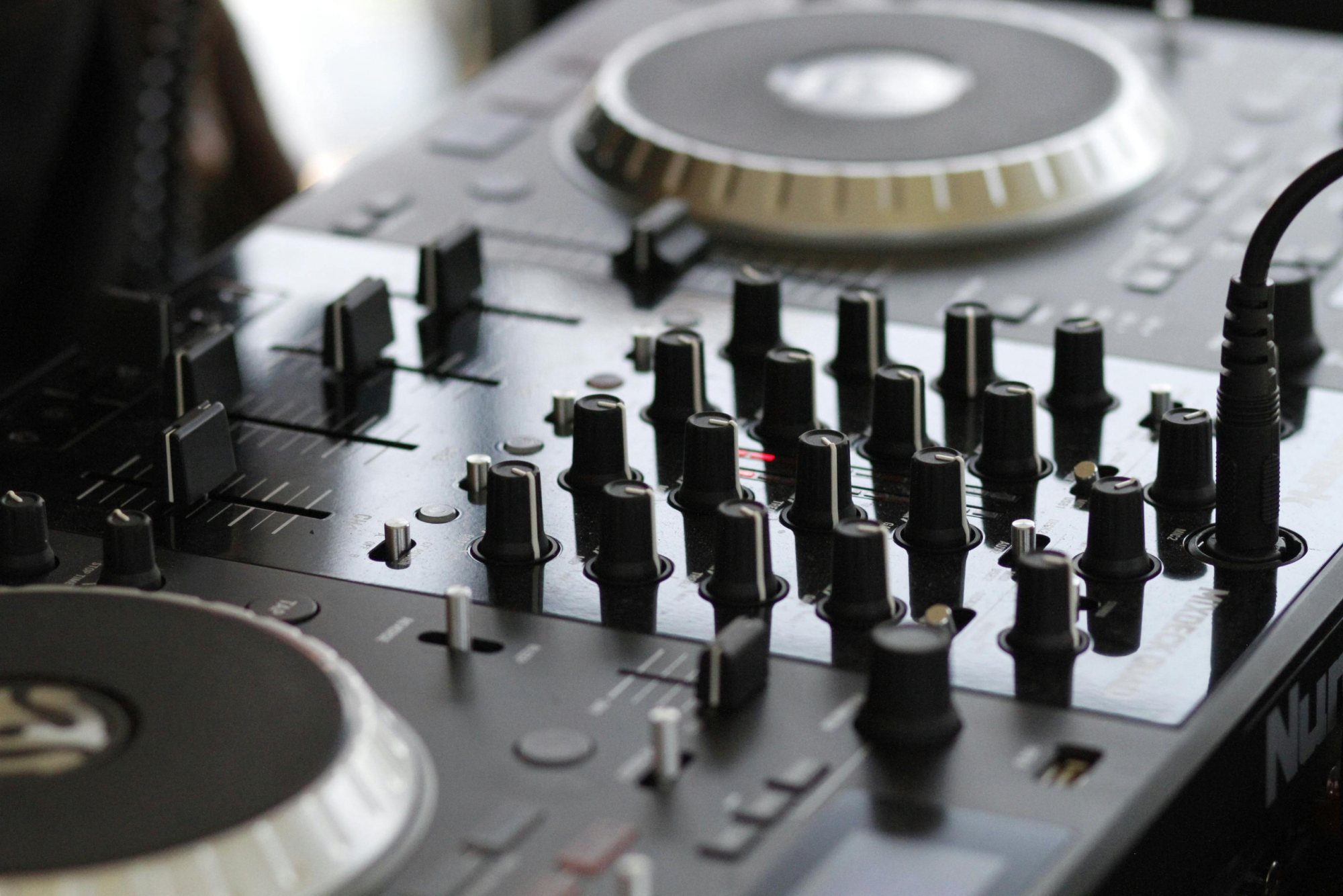 Close-up of a professional DJ mixer with controls.