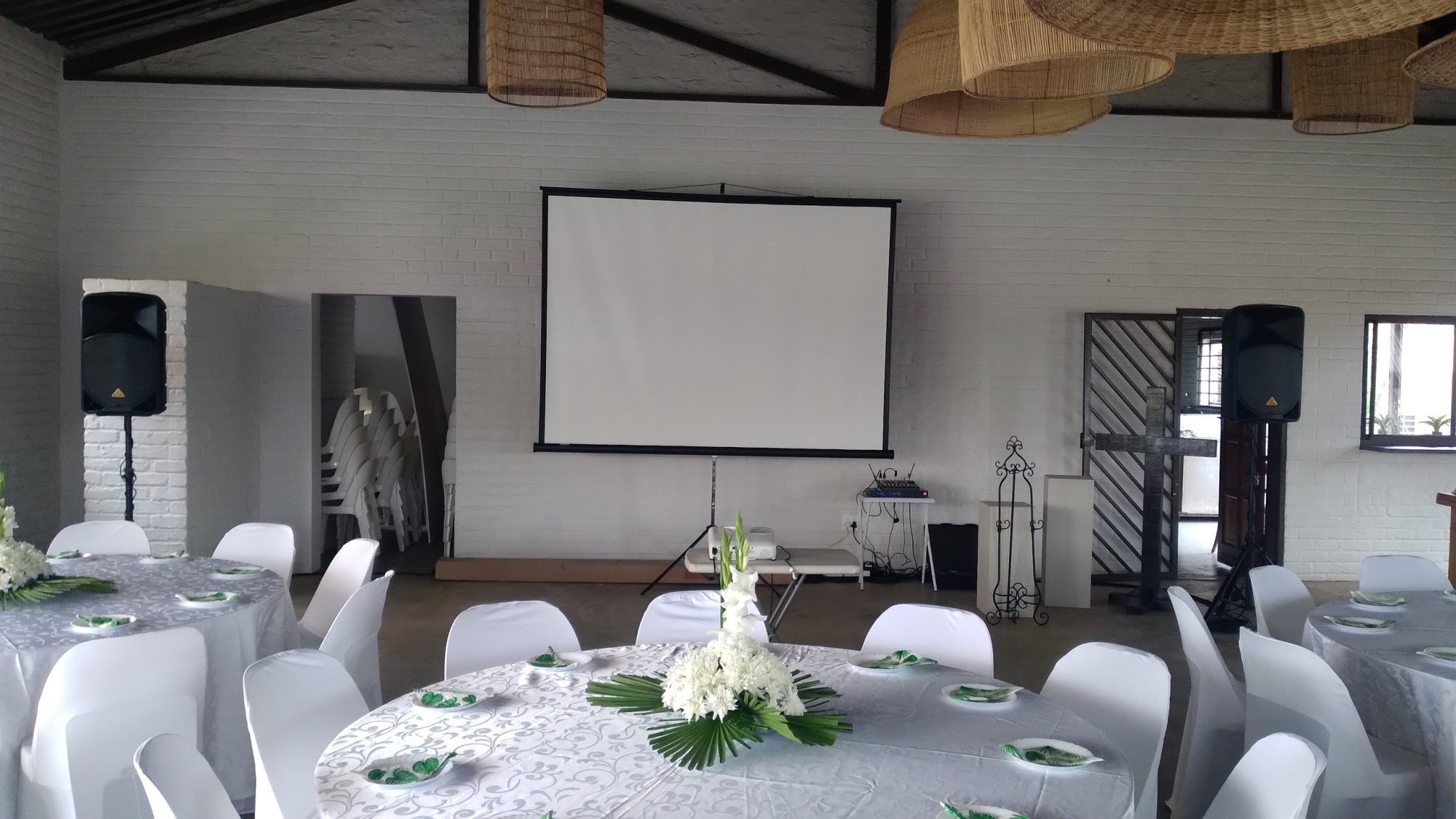 Event setup with a projector screen and PA system in a venue