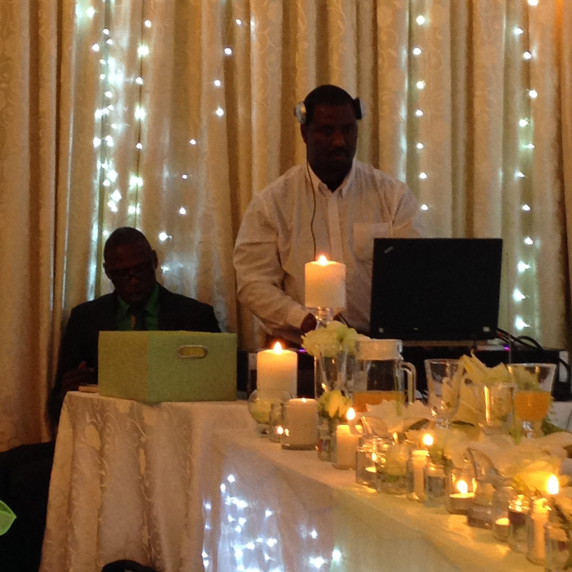 DJ playing music at an event with tables and decorations